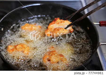 鶏の唐揚げ、からあげ、から揚げ、唐揚。米油で揚げている調理シーン。 77744961