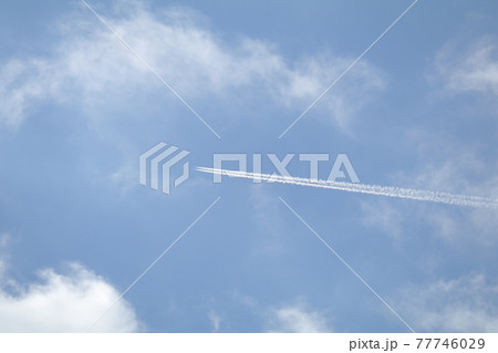 雲の中を一直線に突き進む真っ白な飛行機雲 右から水平の写真素材 