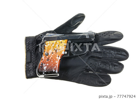 Gun on Leather gloves background. Gun on Leather gloves background. 77747924