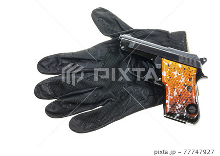 Gun on Leather gloves background. Gun on Leather gloves background. 77747927