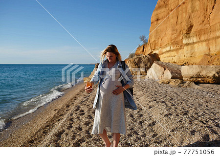 young pregnant woman taking selfie by the sea 77751056