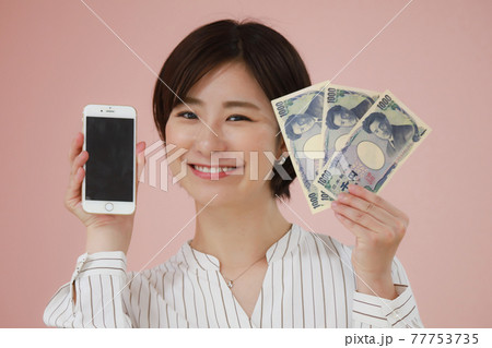 千円札3枚とスマートフォンを持つ女性 千円札3枚とスマートフォンを持つ女性 77753735