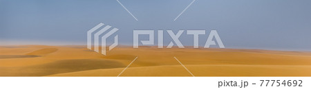 Intentionally blurred panorama of a desert landscape with sand dunes and blue sky Intentionally blurred panorama of a desert landscape with sand dunes and blue sky 77754692