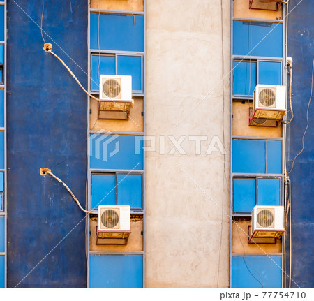 Detailed view of a blue skyscraper with the air conditioning fans behind the windows 77754710