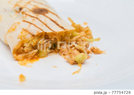 The cut shawarma in a lavash. Juicy stuffing of shawarma. Street food on a white background The cut shawarma in a lavash. Juicy stuffing of shawarma. Street food on a white background 77754729