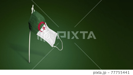Algeria mask on dark blue background. Waving flag of Algeria painted on medical mask on pole. Concept of The banner of the fight against the epidemic coronavirus COVID-19. Copy space 77755441