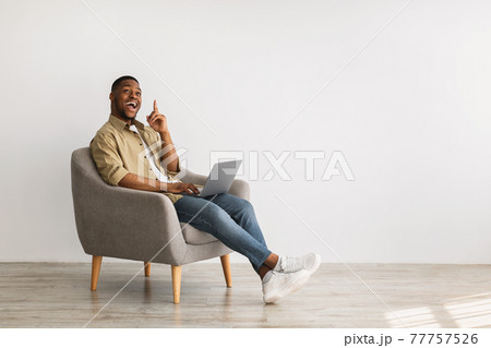 Excited African Man With Laptop Pointing Finger Up, Gray Background Excited African Man With Laptop Pointing Finger Up, Gray Background 77757526
