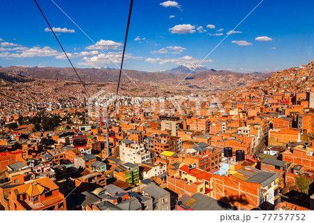 Cable cars or funicular system over orange roofs and buildings of the Bolivian capital, La Paz, Bolivia 77757752