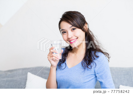 woman with glass of water woman with glass of water 77758242