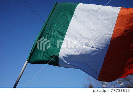 Flag of Ireland in the sky during the celebration of St. Patrick's Day. 77758819