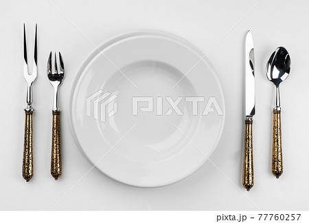 Empty plate with cutlery isolated on white background 77760257