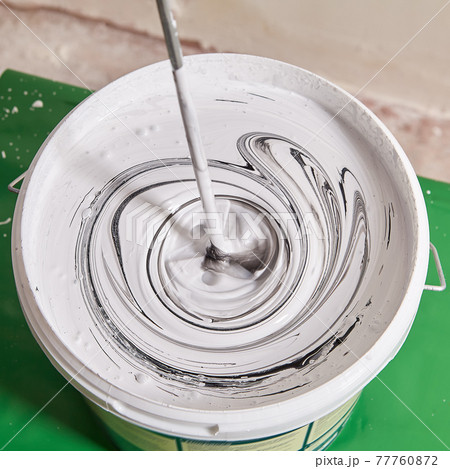 Mixing white paint with black pigment to obtain gray color. 77760872