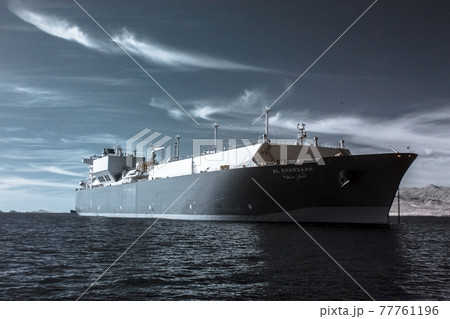 Industrial LNG tanker on the ocean behind a backdrop of calm clouds, infrared 77761196