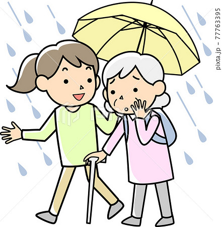 豪雨の中で高齢者の避難を支援する女性 77763395