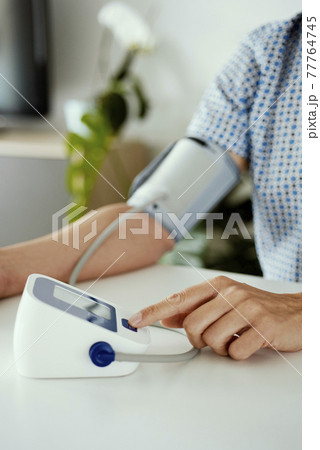 man using an electronic sphygmomanometer 77764745