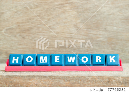 Tile alphabet letter with word homework in red color rack on wood background Tile alphabet letter with word homework in red color rack on wood background 77766282
