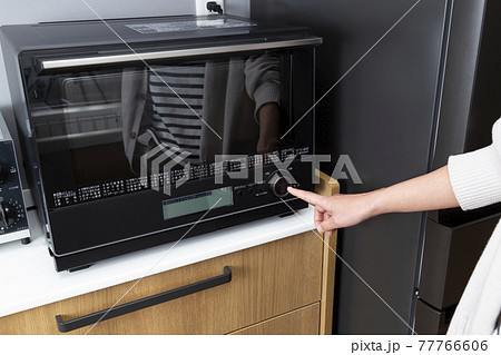電子レンジを使う主婦の手元 77766606