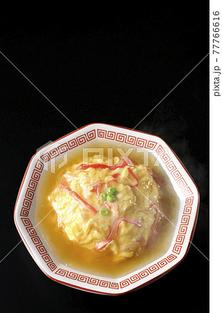 熱々餡かけ中華風オムライス、天津飯を黒背景で撮影（俯瞰） 77766616