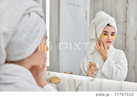 beautiful woman with eye patches in white bathrobes in bathroom 77767010
