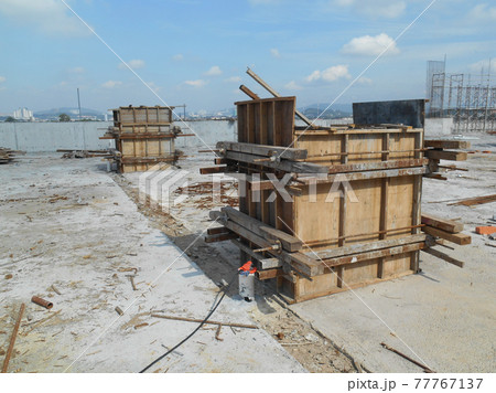 KUALA LUMPUR, MALAYSIA -SEPTEMBER 19, 2016: Column timber form work and reinforcement bar at the construction site. The structure supported by temporary wood support KUALA LUMPUR, MALAYSIA -SEPTEMBER 19, 2016: Column timber form work and reinforcement bar at the construction site. The structure supported by temporary wood support 77767137