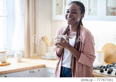 Domestic Relax. Portrait Of Cheerful Black Woman Drinking Coffee In Kitchen Interior 77767581