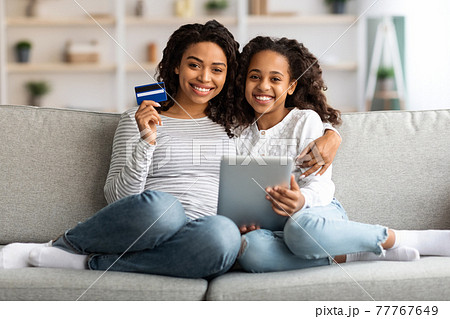 Beautiful african american mother and kid shopping on tablet Beautiful african american mother and kid shopping on tablet 77767649