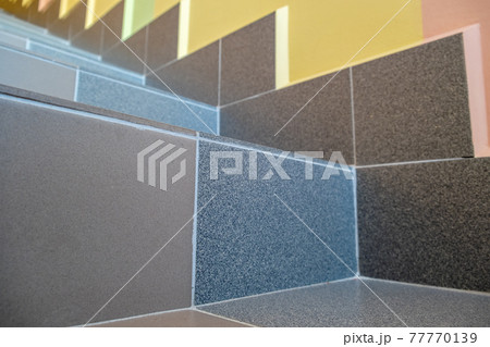 Wide staicase covered with ceramic tiles indoors in a house interior. Wide staicase covered with ceramic tiles indoors in a house interior. 77770139