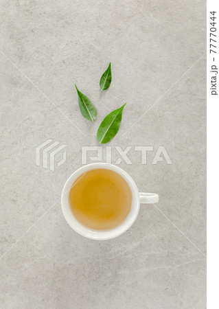 Cup of fresh green tea with tea leaves. Flat lay, top view. Tea concept Cup of fresh green tea with tea leaves. Flat lay, top view. Tea concept 77770444
