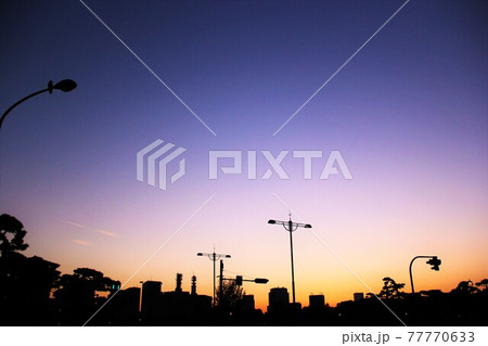 都会の黄昏時:鮮やかなグラデーション空に街灯や建物が美しく浮かび上がる夕焼けの景色素材 都会の黄昏時:鮮やかなグラデーション空に街灯や建物が美しく浮かび上がる夕焼けの景色素材 77770633