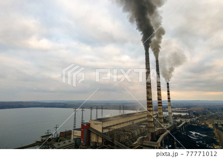 Aerial view of coal power plant high pipes with black smoke moving up polluting atmosphere. 77771012
