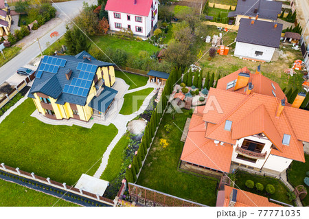 Aerial view of a rural private house with solar photovoltaic panels for producing clean electricity on roof. Autonomous home concept. Aerial view of a rural private house with solar photovoltaic panels for producing clean electricity on roof. Autonomous home concept. 77771035