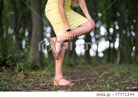 Woman holding knee with hands having strong pain. 77771244