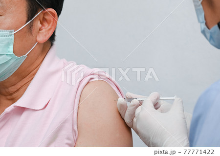 Doctor giving COVID-19 Vaccine shot to patient for can help stop pandemic, COVID-19 vaccines can help reduce the transmission of the new coronavirus from person to person 77771422