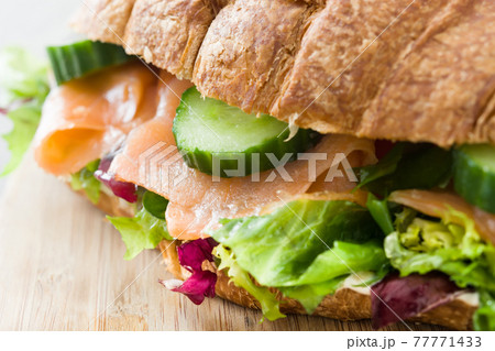 Croissant sandwich with salmon and vegetables Croissant sandwich with salmon and vegetables 77771433