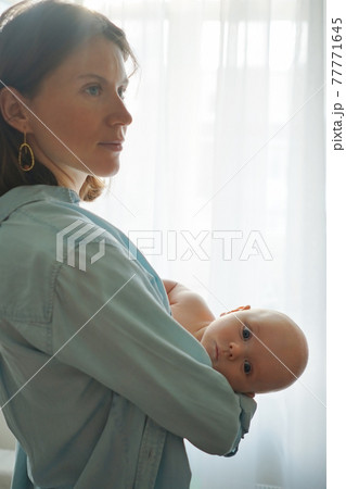 Mother with baby standing at home 77771645