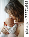 Mother kissing baby tenderly in forehead 77771648