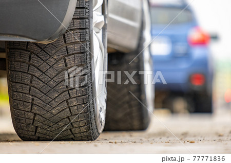 Closeup of parked car on a city street side with new winter rubber tires. 77771836