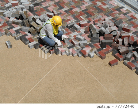 MALACCA, MALAYSIA -MAC 08, 2017: Construction workers installing and arranging precast concrete pavers stone for the road at the construction site. MALACCA, MALAYSIA -MAC 08, 2017: Construction workers installing and arranging precast concrete pavers stone for the road at the construction site. 77772440