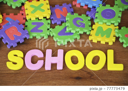 SCHOOL conceptual word made from rubber foam and colorful rubber puzzle alphabet randomly arrange. Isolated on wood texture background. SCHOOL conceptual word made from rubber foam and colorful rubber puzzle alphabet randomly arrange. Isolated on wood texture background. 77773479