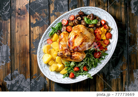 Grilled cooked whole chicken with grilled bell pepper and potatoes Grilled cooked whole chicken with grilled bell pepper and potatoes 77773669