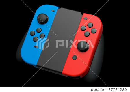 Portable video game controllers attached to touch screen on black background 77774289