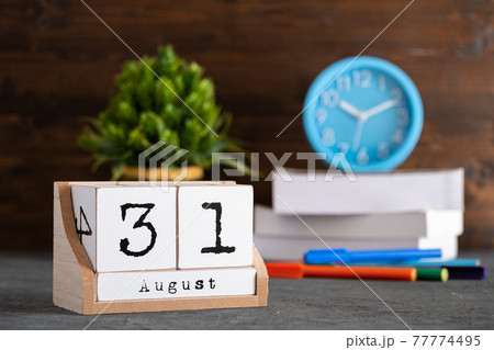 August 31st. August 31 wooden cube calendar with blur objects on background. 77774495