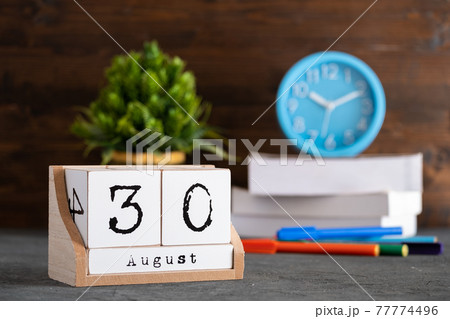 August 30th. August 30 wooden cube calendar with blur objects on background. 77774496