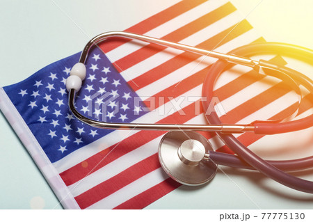 USA medicine background. Stethoscope on the American flag. Healthcare and medical services in the USA concept. 77775130