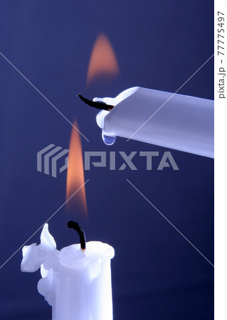 two burning white candles on a blue background two burning white candles on a blue background 77775497