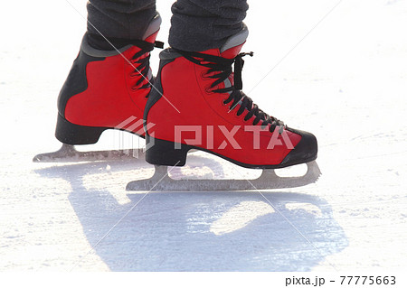 feet in red skates on an ice rink feet in red skates on an ice rink 77775663