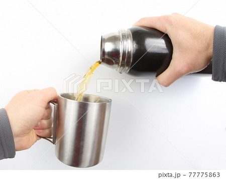 tea is poured into a mug of thermos tea is poured into a mug of thermos 77775863
