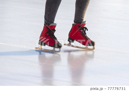 feet in red skates on an ice rink. hobbies and leisure. winter sports feet in red skates on an ice rink. hobbies and leisure. winter sports 77776731