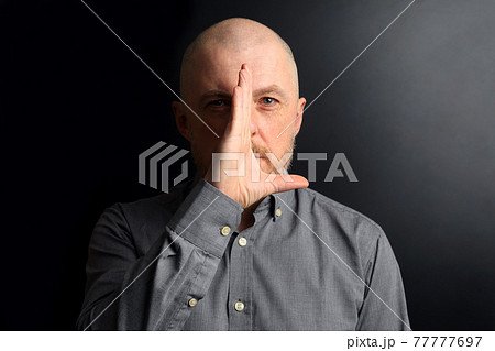 Bearded man shielded half of his face from the light with his palm 77777697