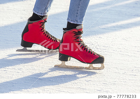 feet in red skates on an ice rink. hobbies and leisure. winter sports feet in red skates on an ice rink. hobbies and leisure. winter sports 77778233